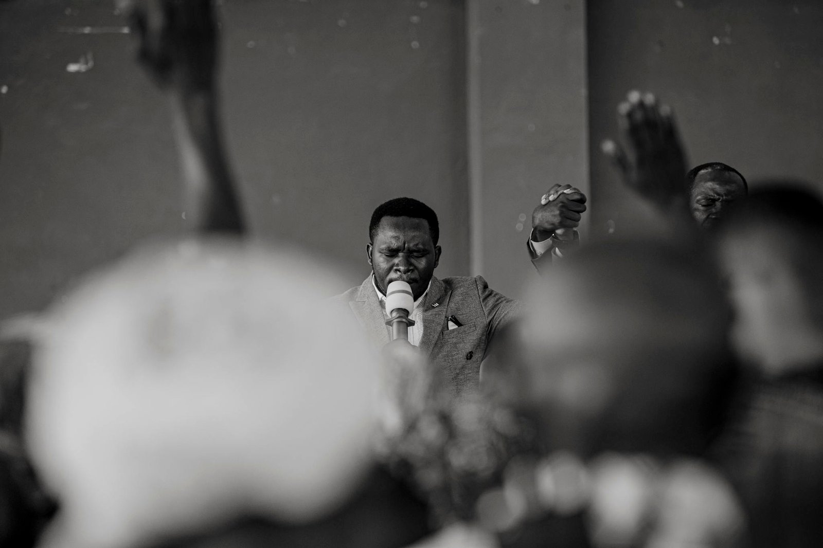 Black and white photograph capturing an emotional preacher speaking to a crowd.